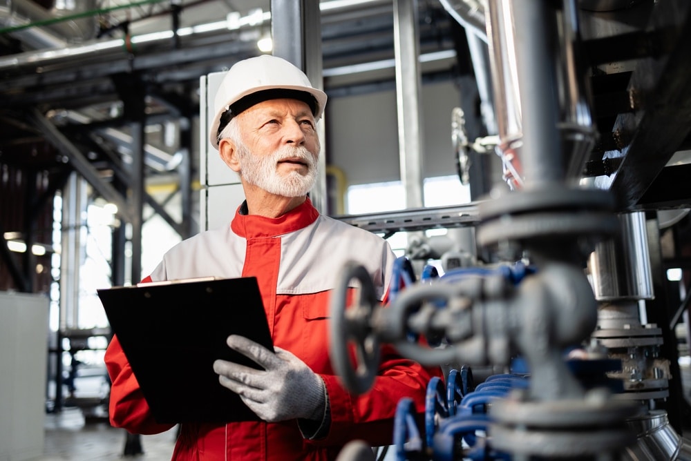 Experienced,Worker,Wearing,Hard,Hat,Checking,Pipeline,Valves,And,Equipment
