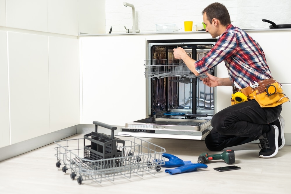 Repairman,Repairing,Dishwasher,With,Screwdriver,In,Kitchen